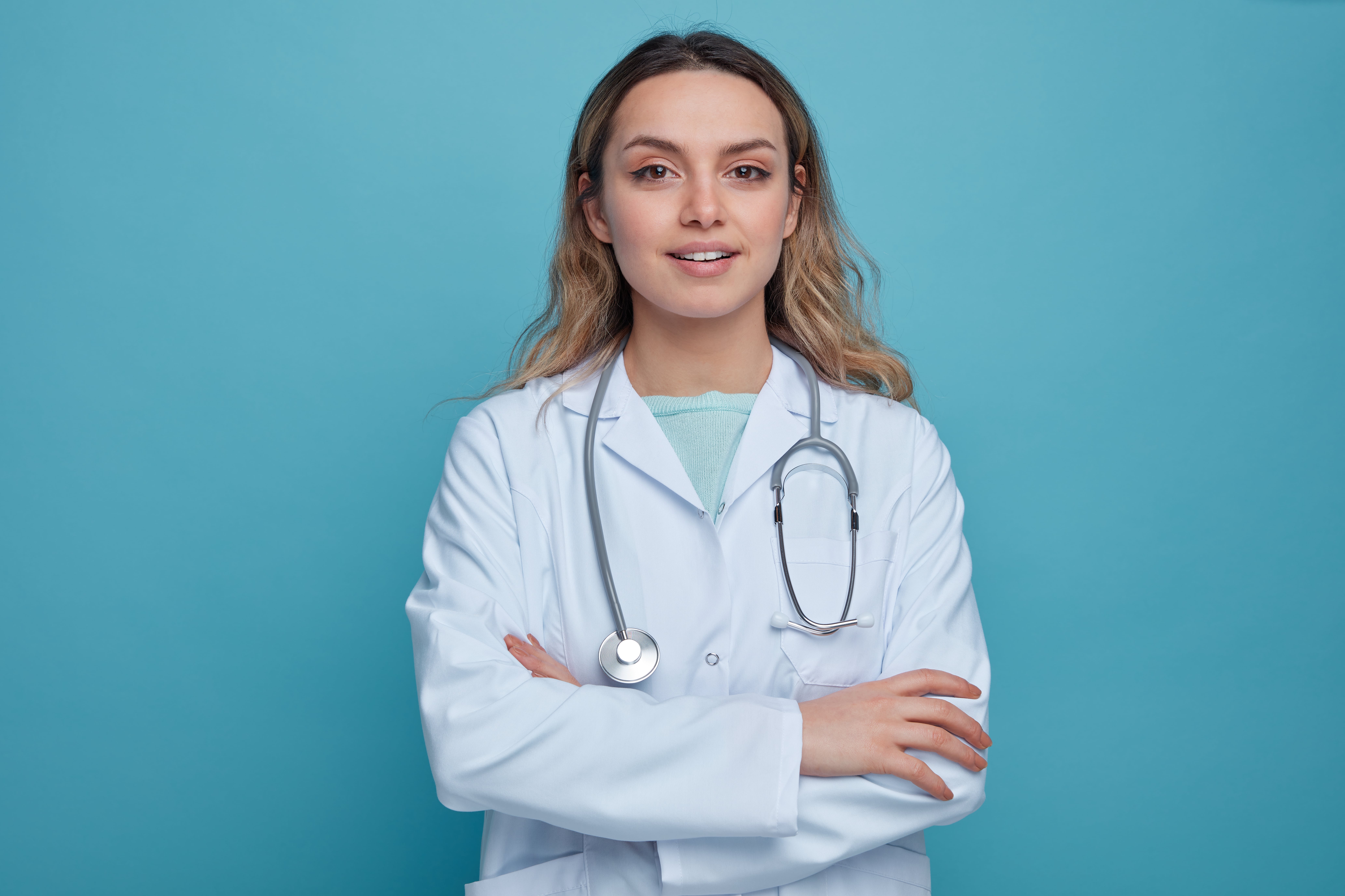 pleased-young-female-doctor-wearing-medical-robe-stethoscope-around-neck-standing-with-closed-posture (2)-min