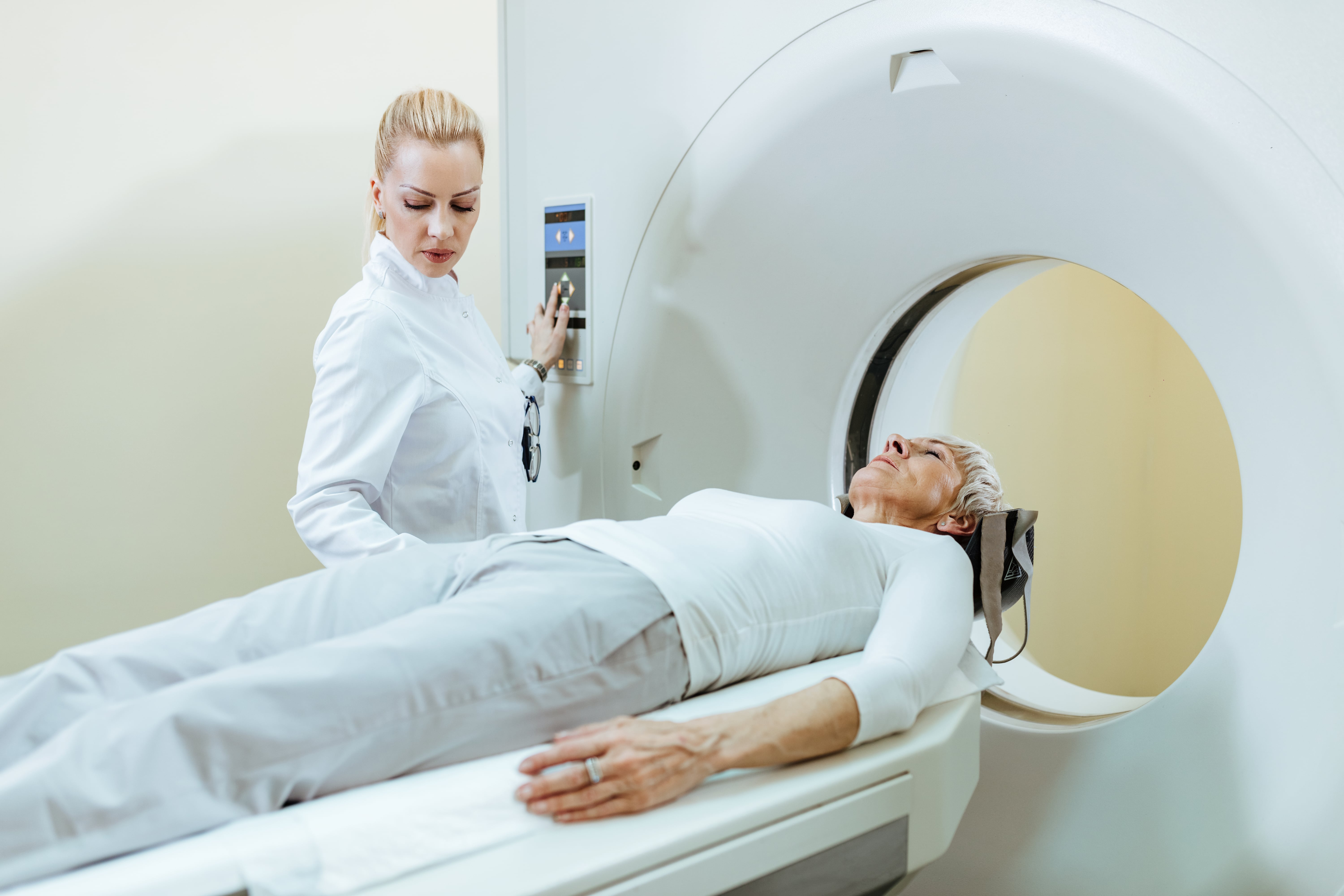 senior-woman-undergoing-mri-scanner-while-doctor-is-supervising-procedure-min